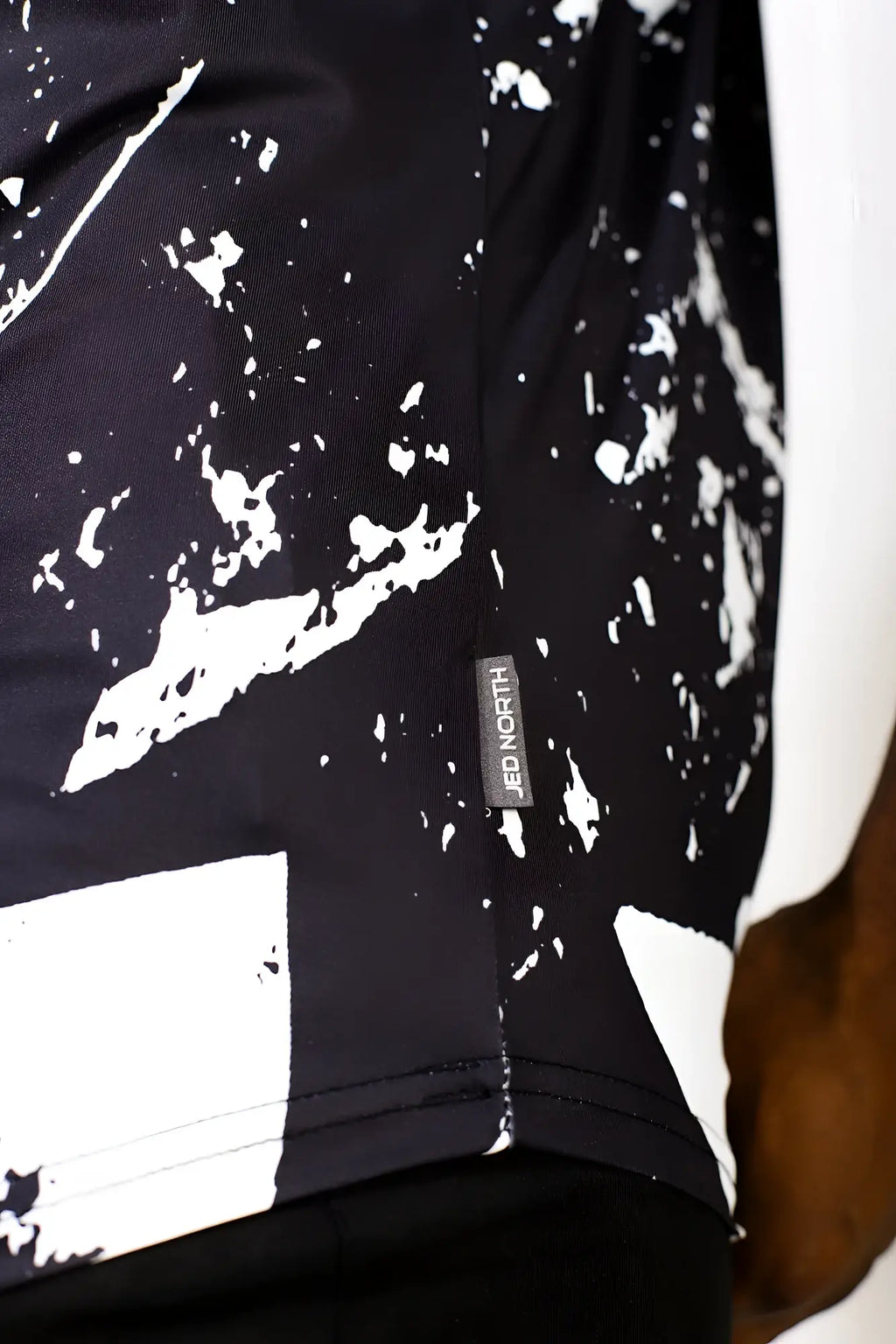 Black and white splatter-patterned graphic muscle stringer athletic shirt with jed north brand tag in abstract black