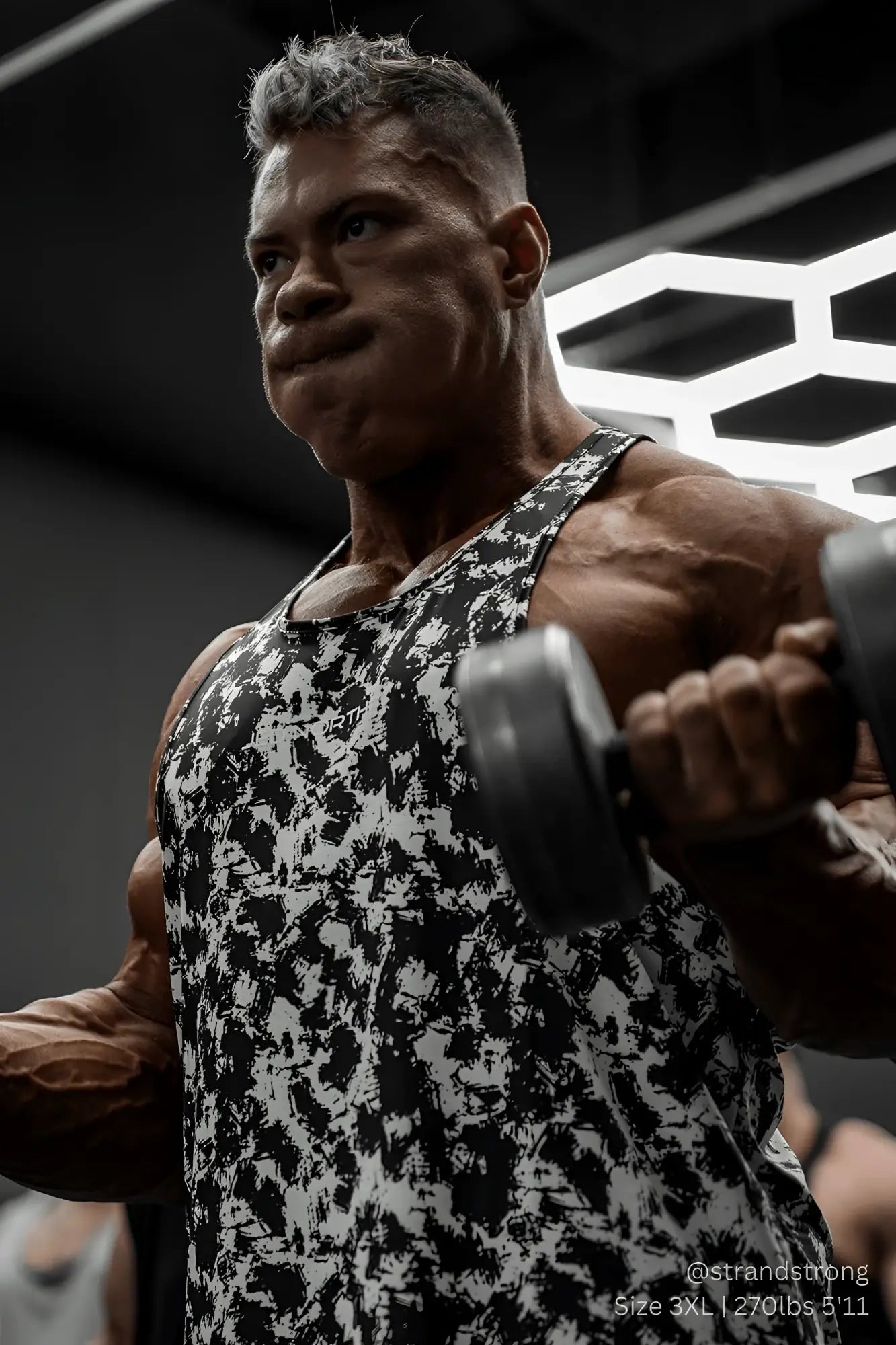 A muscular man wearing a jed north graphic muscle stringer tank top with black and white paint brush abstract pattern