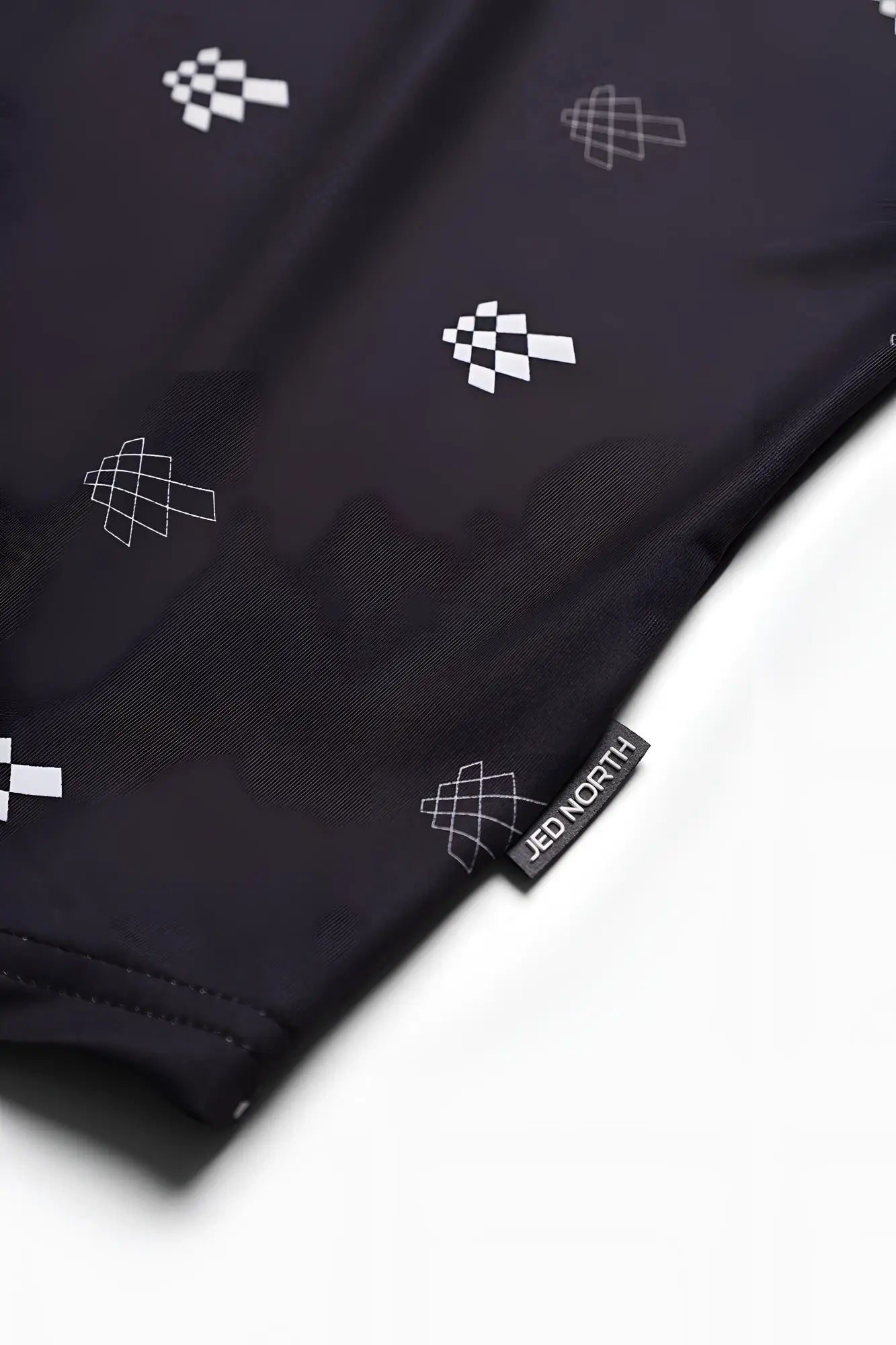 Black jed north graphic muscle stringer featuring white geometric checkered pattern and branded tag