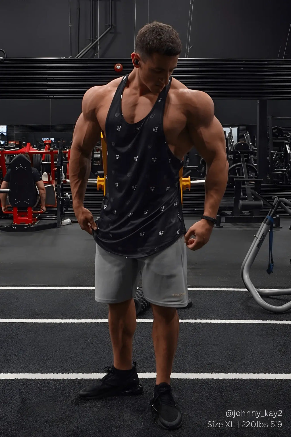 Black jed north graphic muscle stringer tank top with subtle white pattern worn by muscular individual in gym