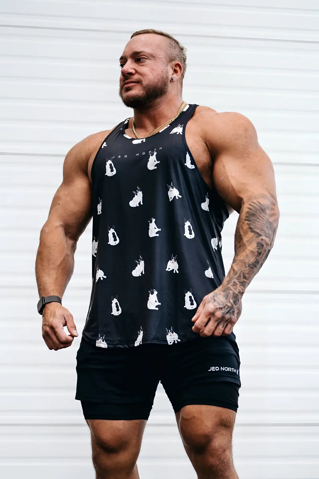 Black graphic muscle stringer tank top featuring white cat silhouettes printed across front for casual wear