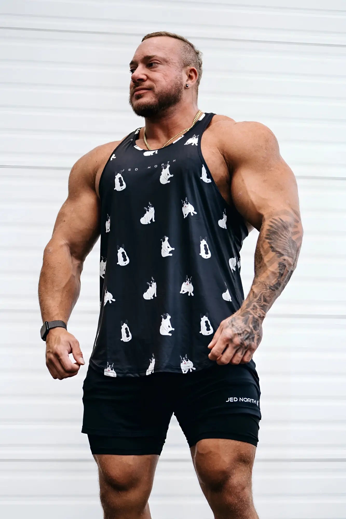 Black graphic muscle stringer tank top featuring white cat silhouettes printed across front for casual wear