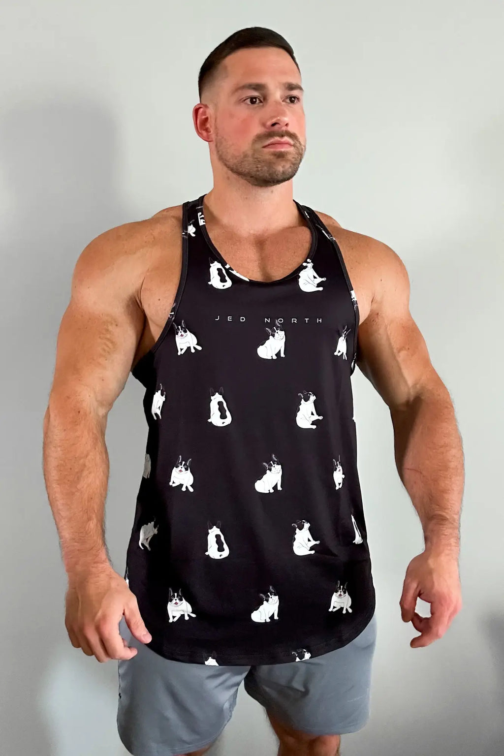 Black graphic muscle stringer tank top with white french bulldog silhouettes and jed north text across the chest