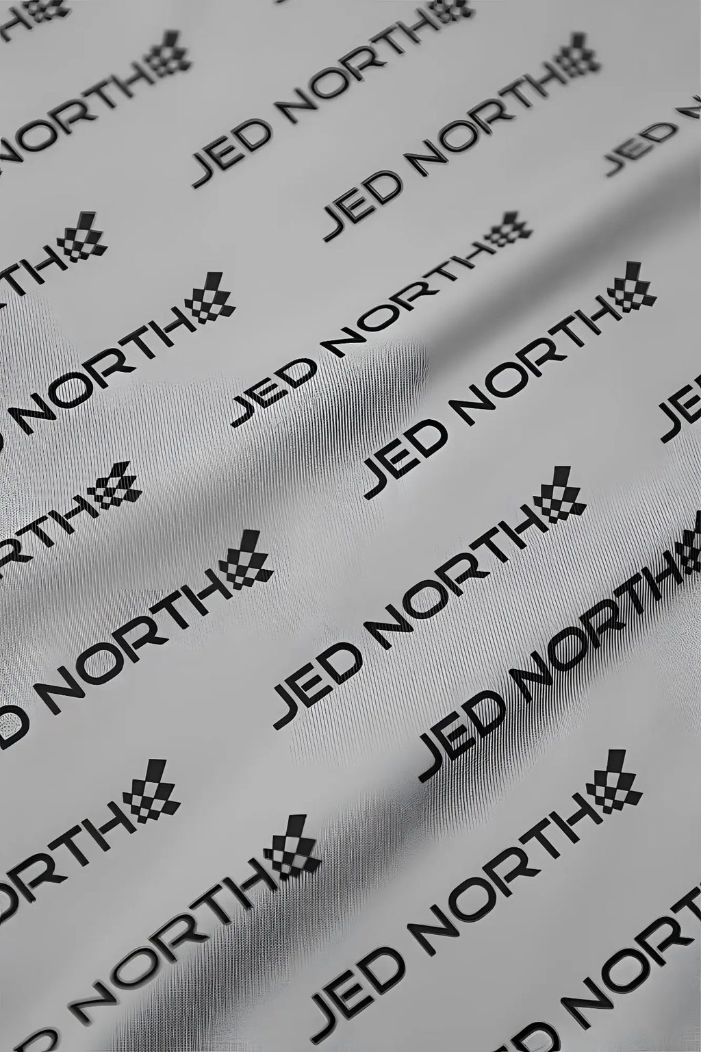 White fabric featuring repeating black jed north logo and checkered flag emblem from jed north graphic muscle stringer gray jn logo