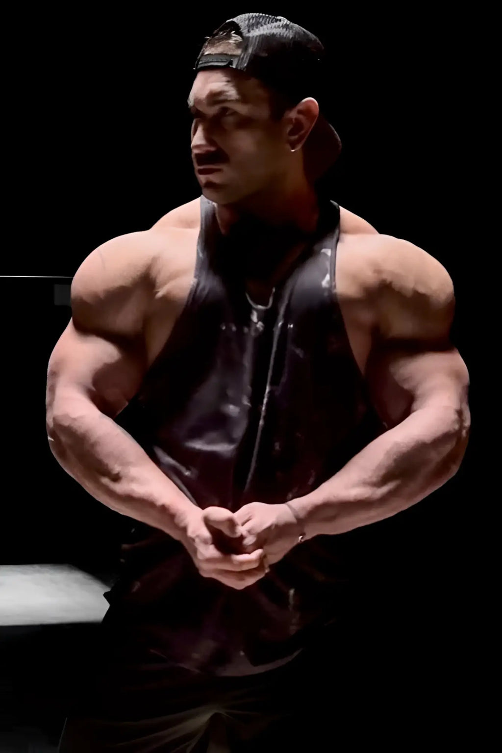 A black glossy muscle stringer tank top by jed north worn by a muscular individual showcasing fit design
