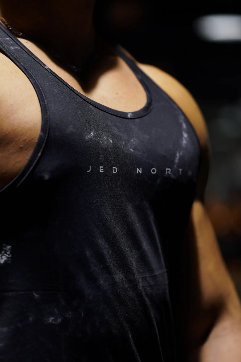 Black Jed North graphic muscle stringer tank top in racerback style with white logo showing signs of use and sweat