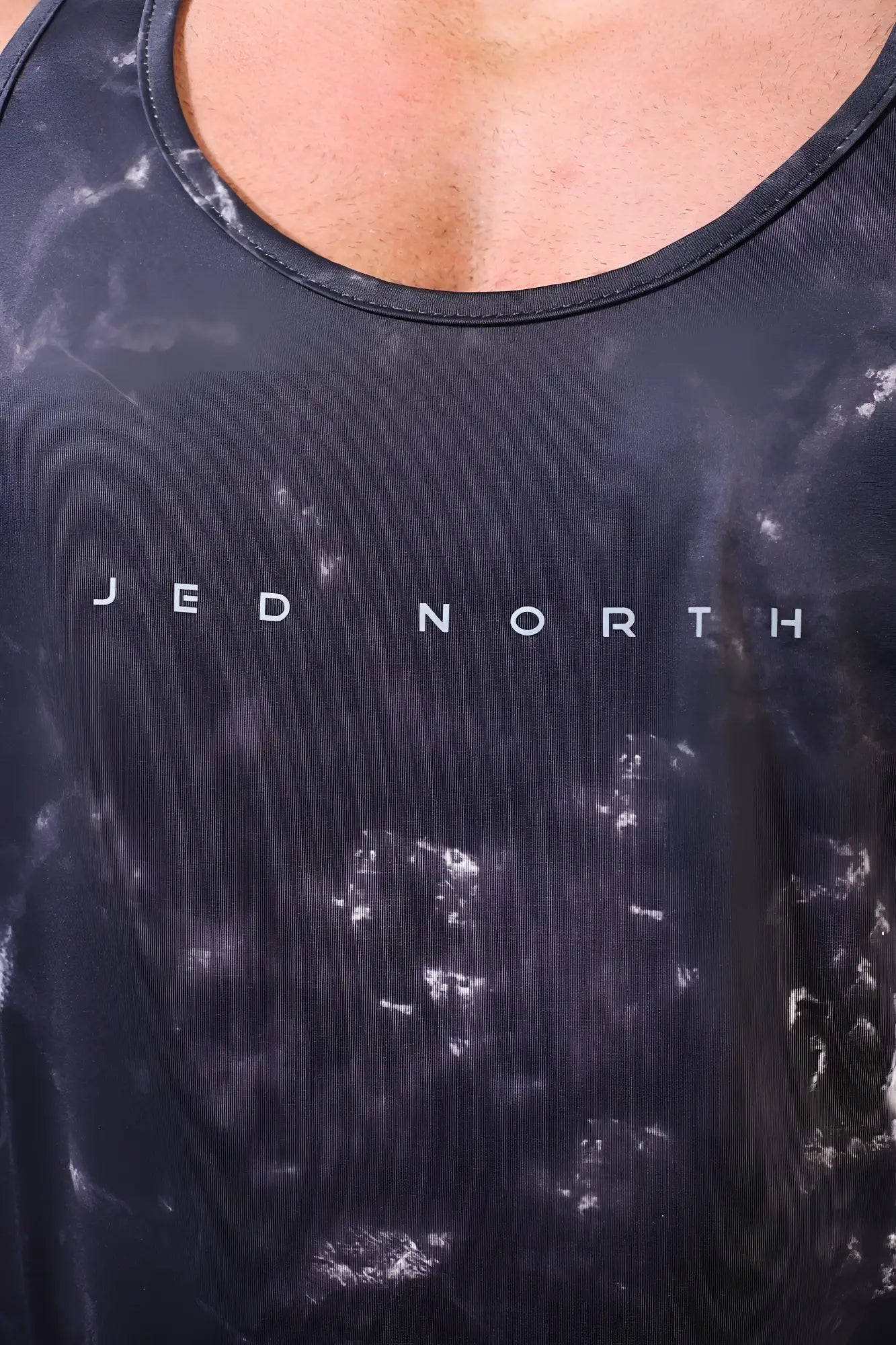 Black tie-dye jed north graphic muscle stringer tank top with white lettering across the chest