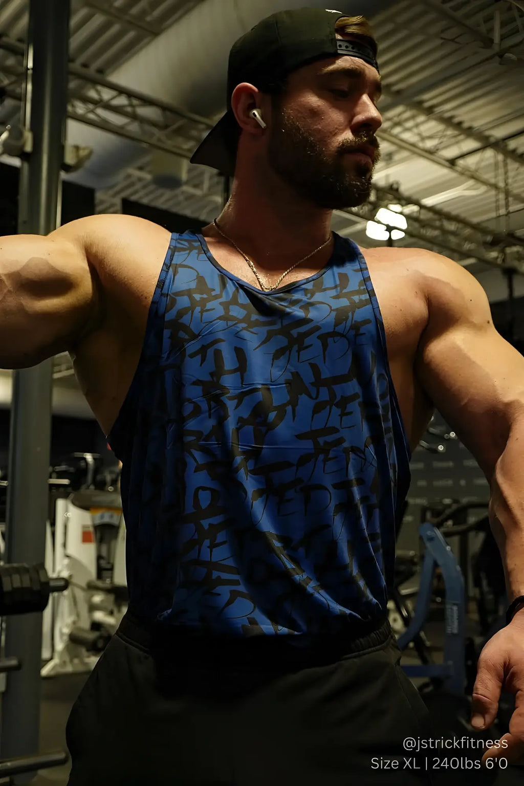 Blue athletic tank top with black abstract graffiti pattern designed for muscle definition and performance wear