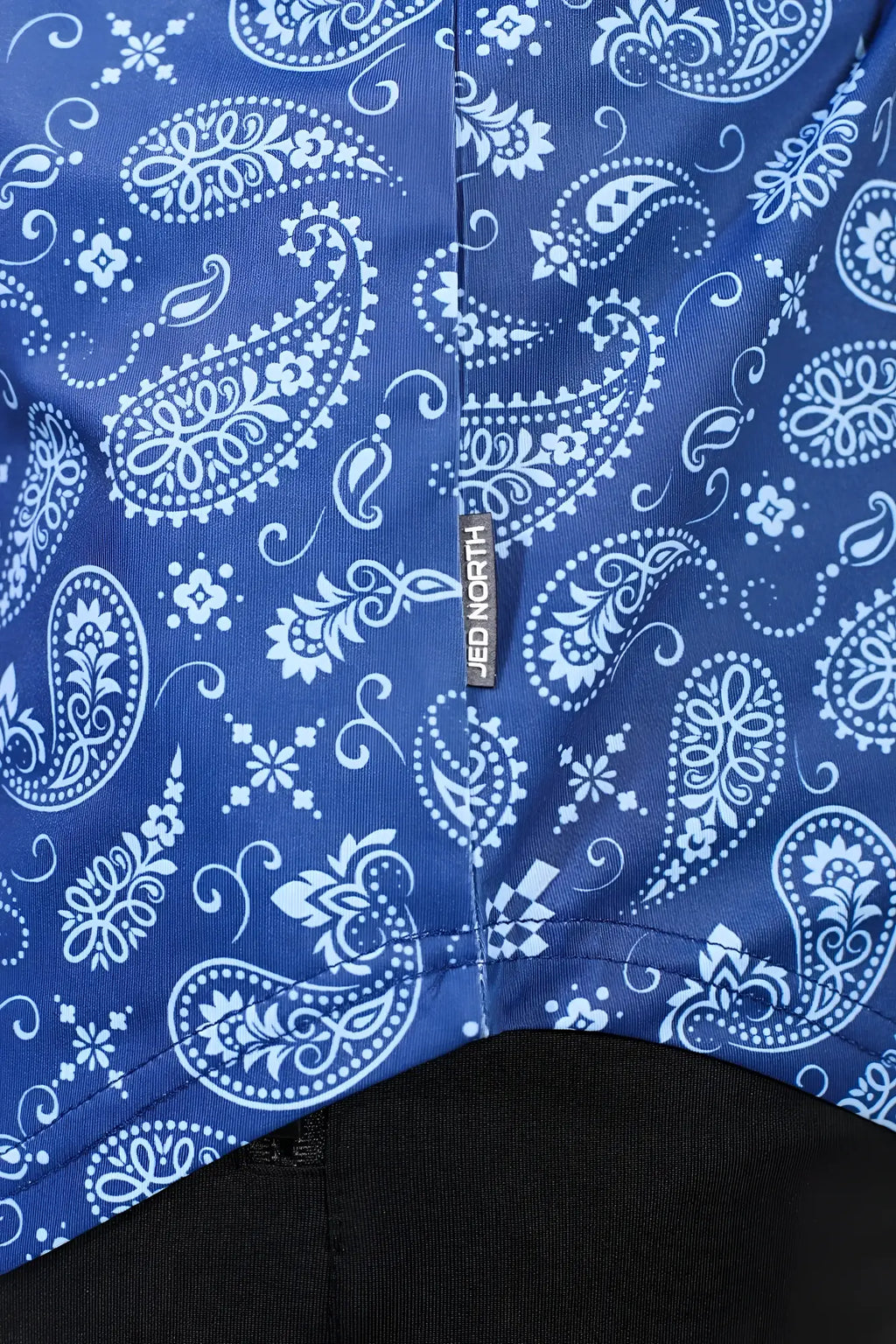 Blue and white paisley patterned fabric of jed north graphic muscle stringer featuring a jed north brand tag