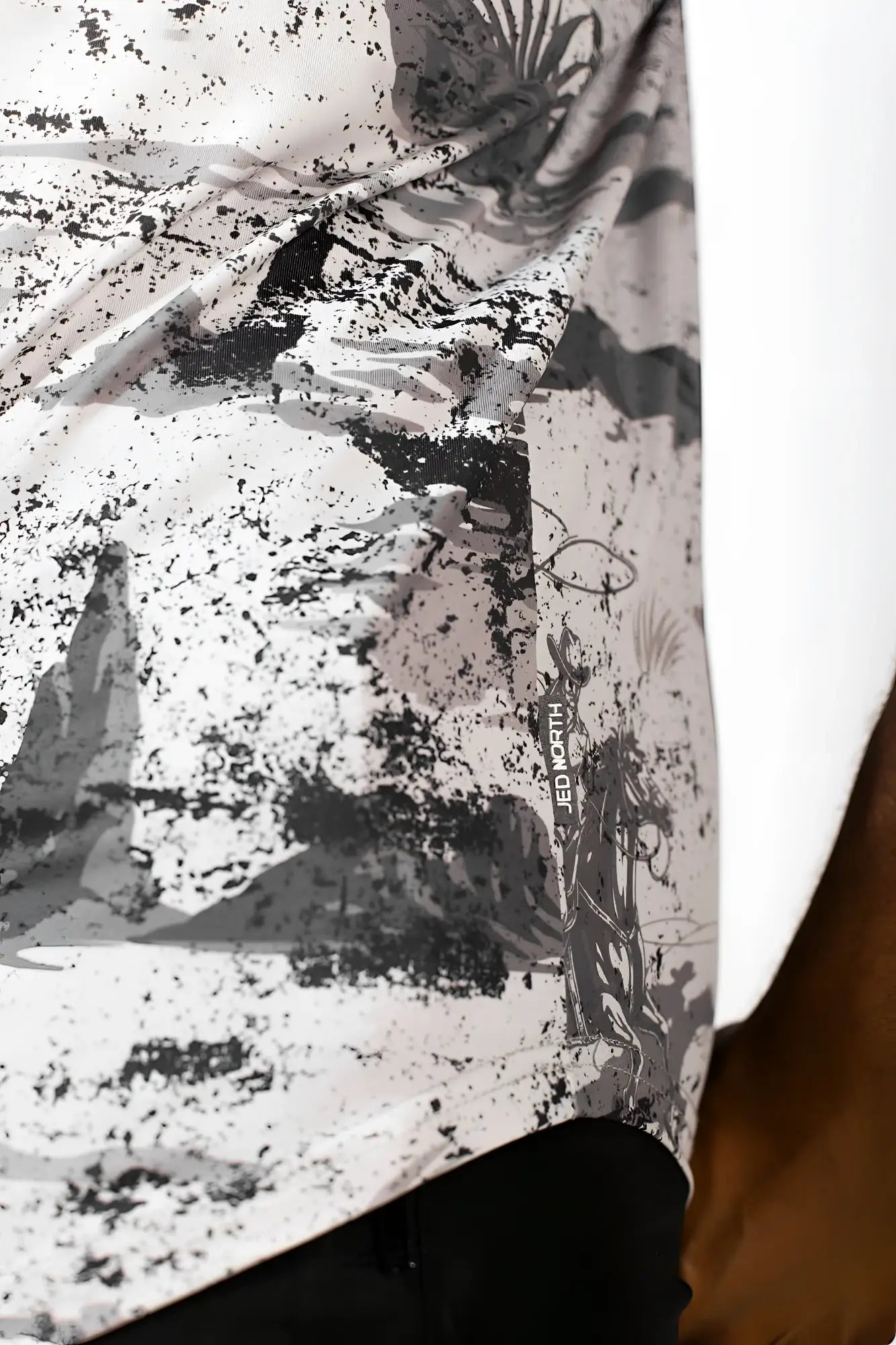 A white and black graphic muscle stringer shirt with a distressed palm tree print and splattered rugged outlaw design
