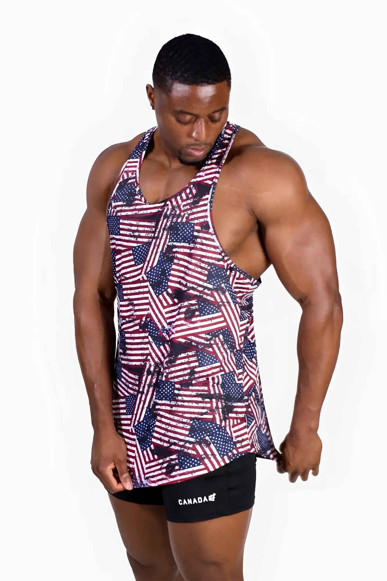 A muscular man wearing a graphic muscle stringer with an overlapping USA flag pattern in red white and blue