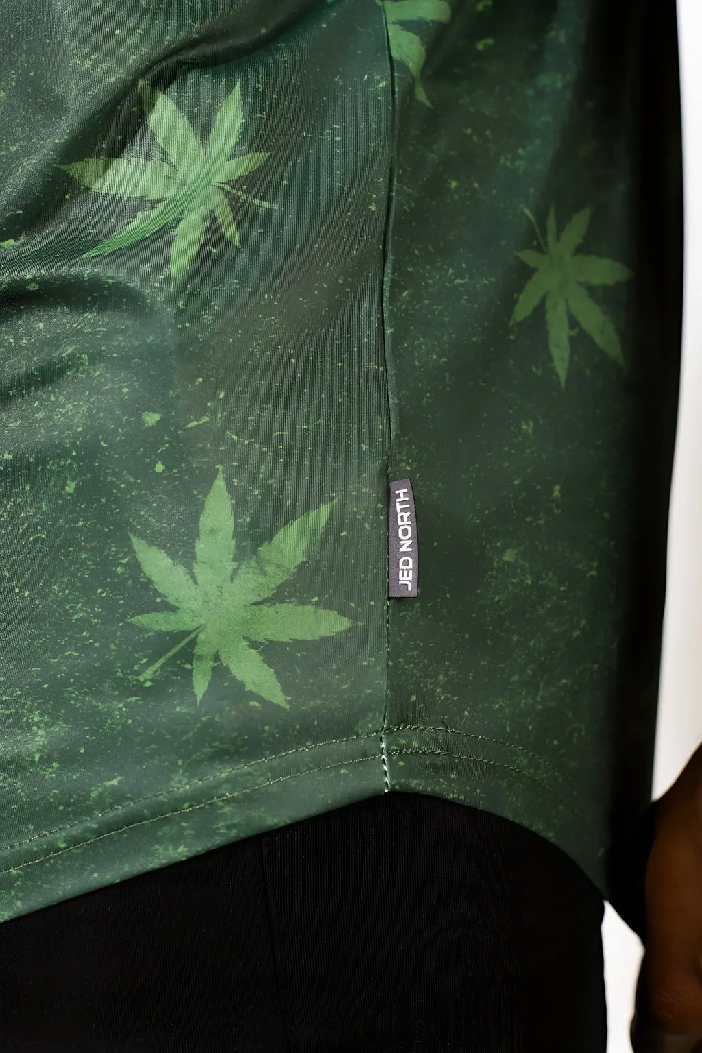 Dark green short-sleeved graphic muscle stringer with speckled texture and light green cannabis leaf print