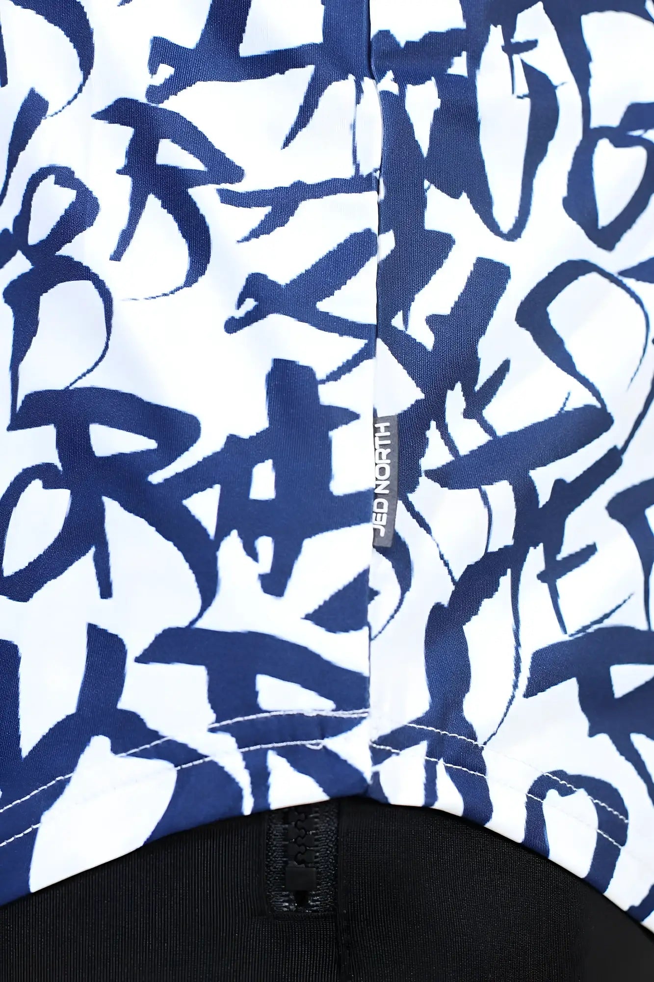 White jed north graphic muscle stringer jacket with bold navy blue graffiti lettering and black zipper at the bottom
