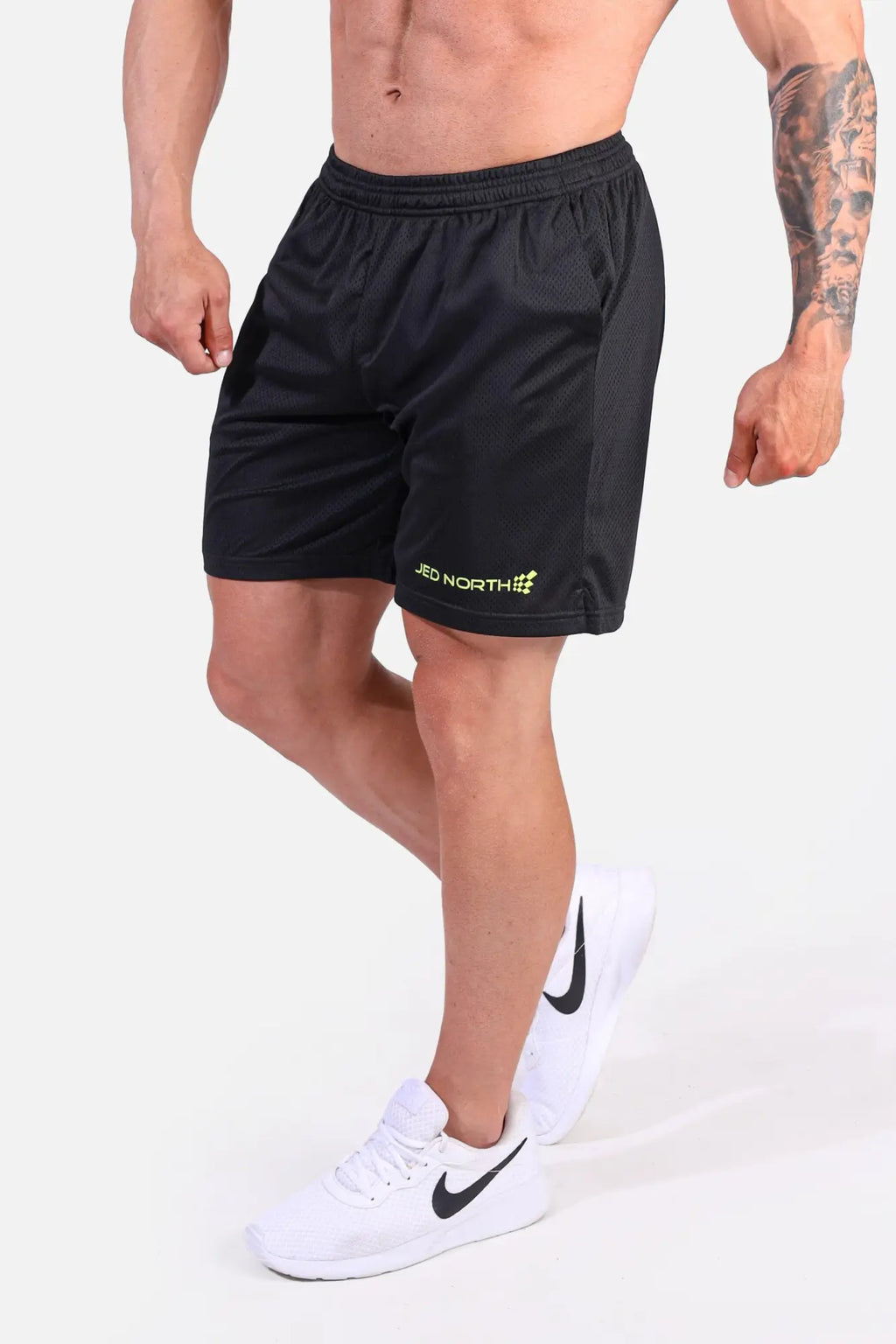 Jed North Jersey Mesh 7.5 inch gym shorts in black with breathable mesh fabric and a subtle yellow logo on the lower left leg