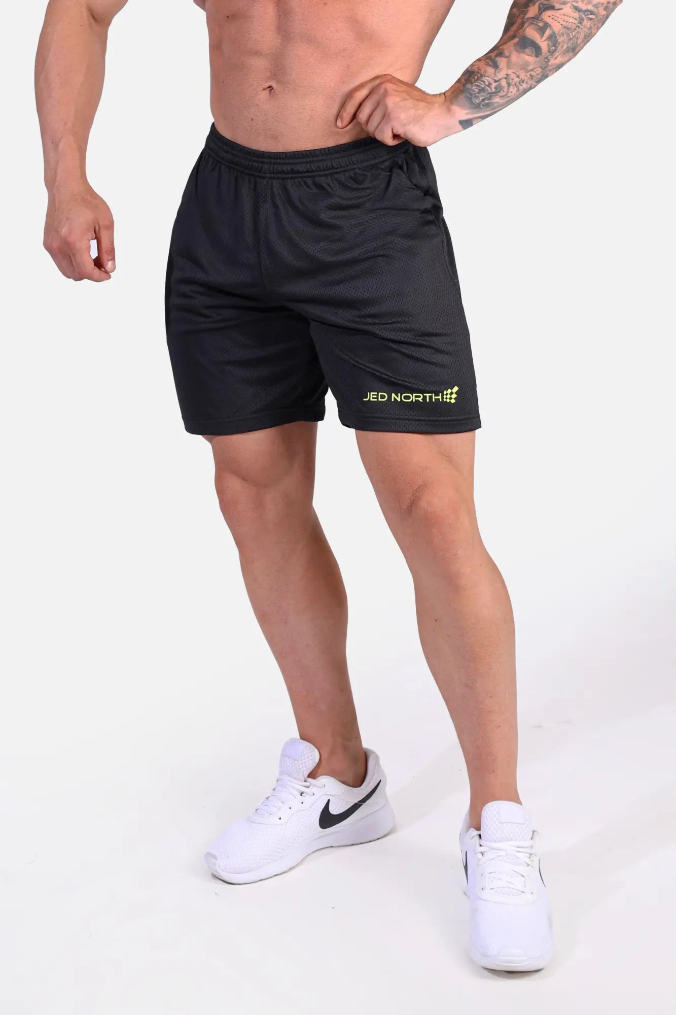 Jed north jersey mesh 7.5 inch gym shorts in black with subtle textured fabric and small yellow logo on lower left leg