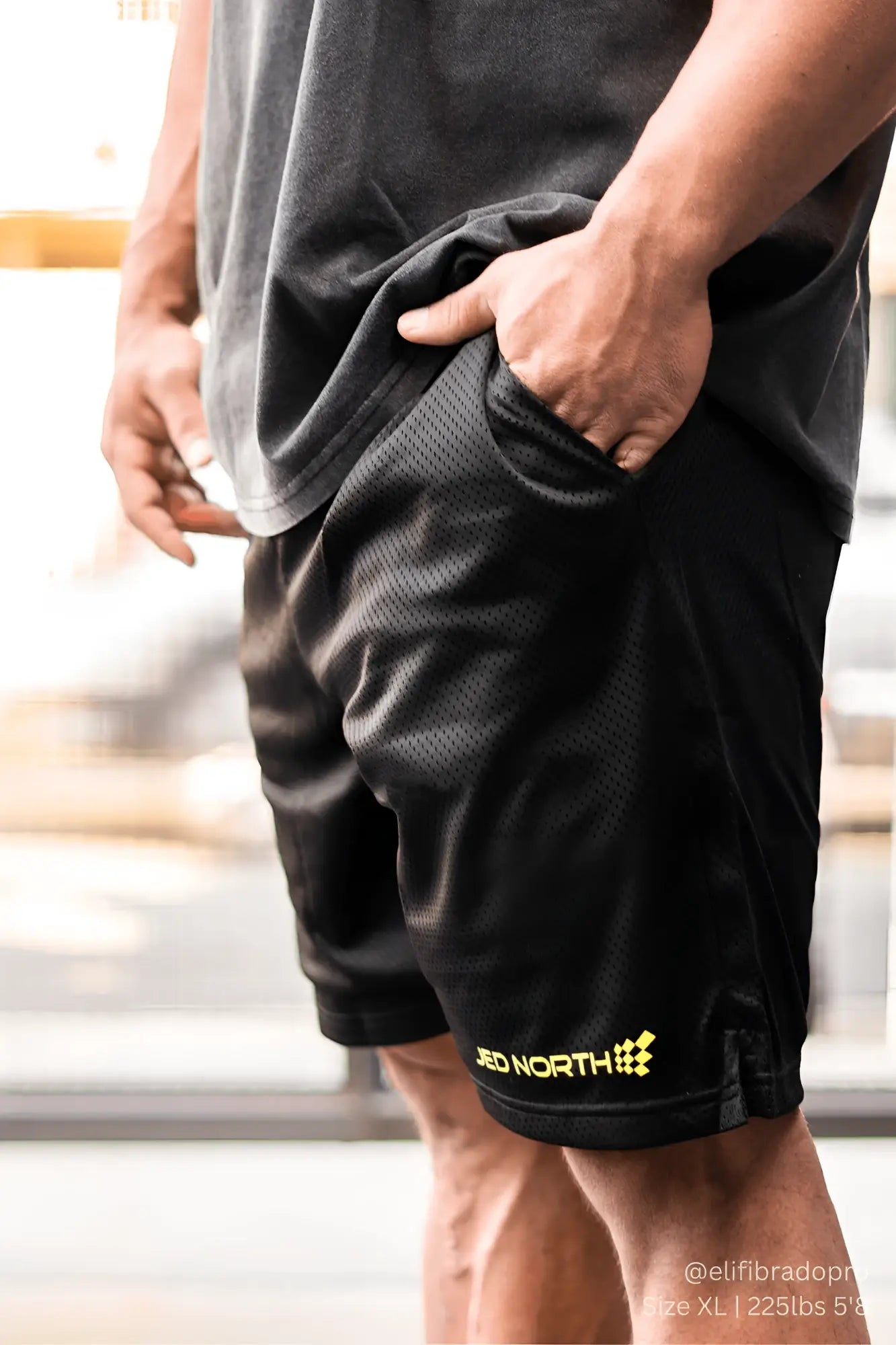 Black jed north jersey mesh 7.5 inch gym shorts with yellow red north logo on lower leg, breathable athletic wear