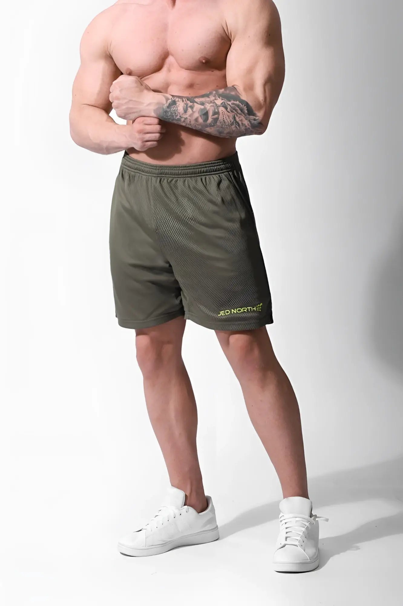 Olive green jed north jersey mesh 7.5 inch gym shorts with subtle yellow logo on lower right leg
