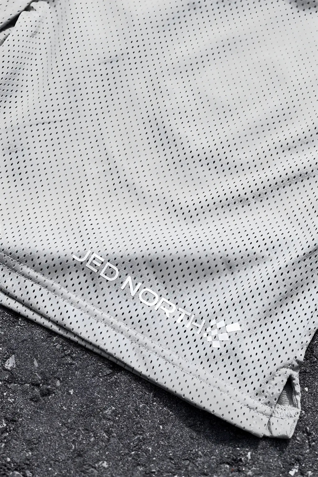 Gray perforated mesh jed north jersey gym shorts in polar silver with embroidered branding along the hem
