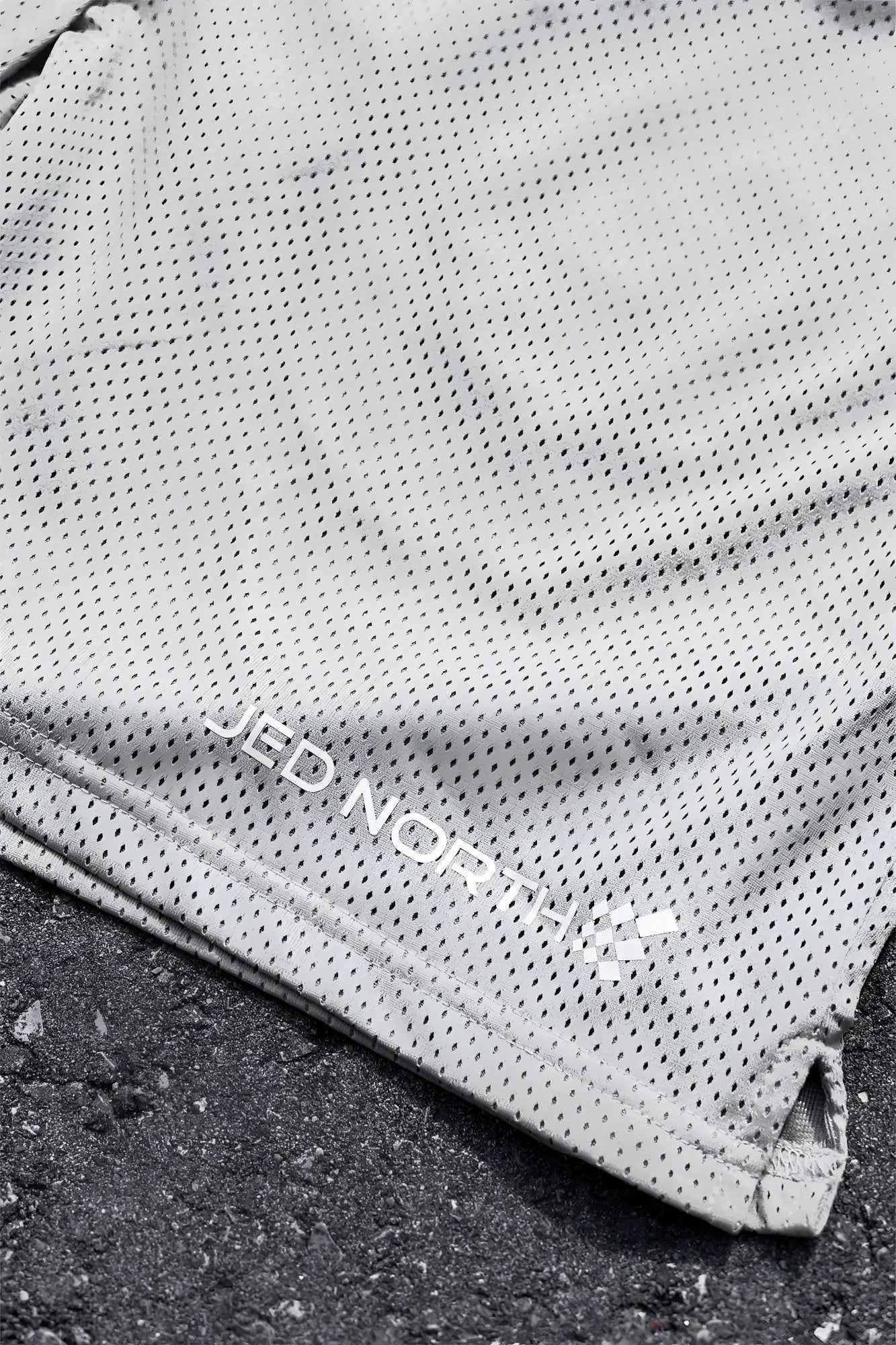 Gray perforated mesh jed north jersey gym shorts in polar silver with embroidered branding along the hem