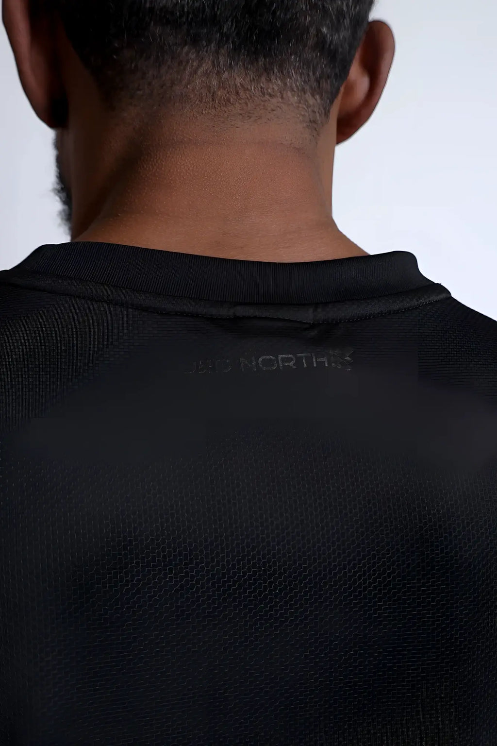 Black north face jn active muscle tee with subtle textured fabric and ribbed crew neckline for performance use