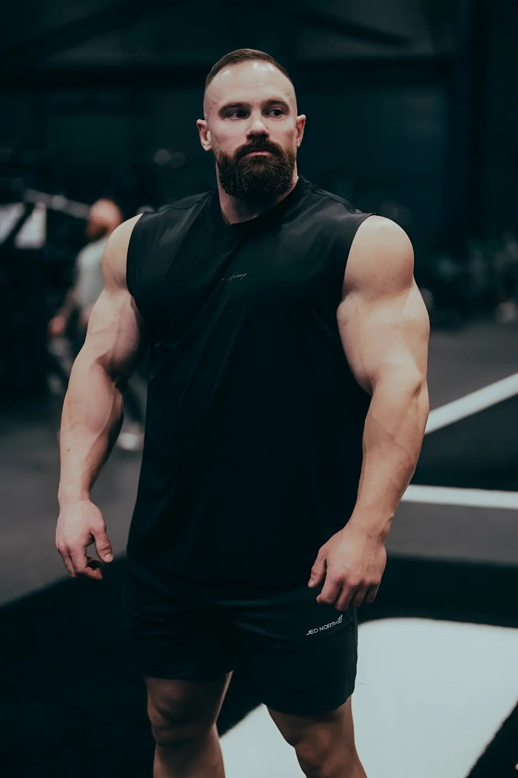 Black sleeveless jn active muscle tee with subtle chest logo designed for athletic performance and comfort