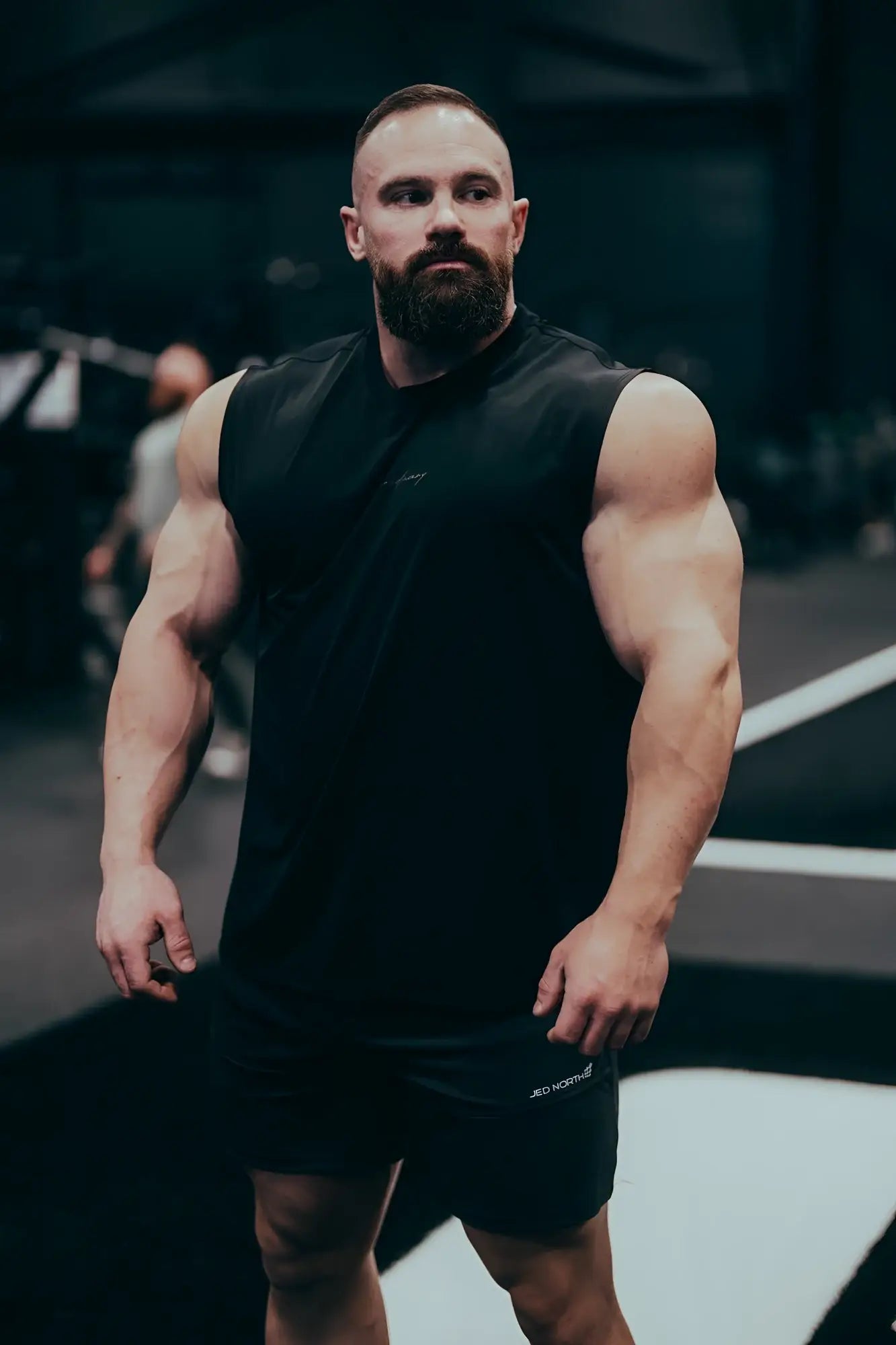 Black sleeveless jn active muscle tee with subtle chest logo designed for athletic performance and comfort
