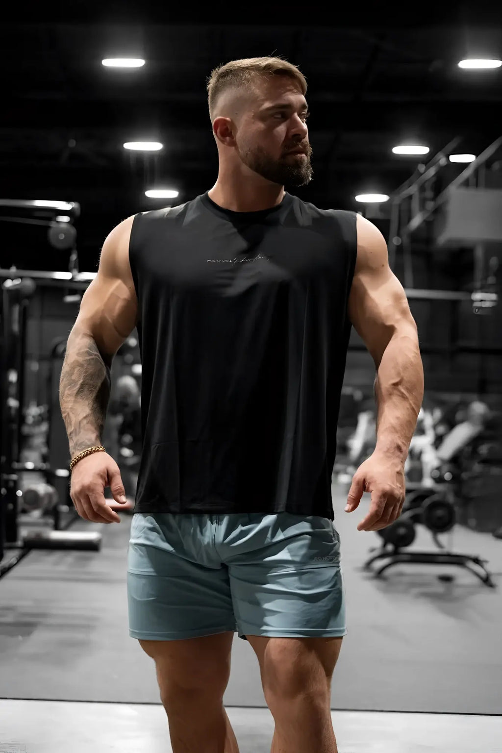 Black sleeveless JN Active muscle tee with subtle chest text designed for athletic performance and comfort
