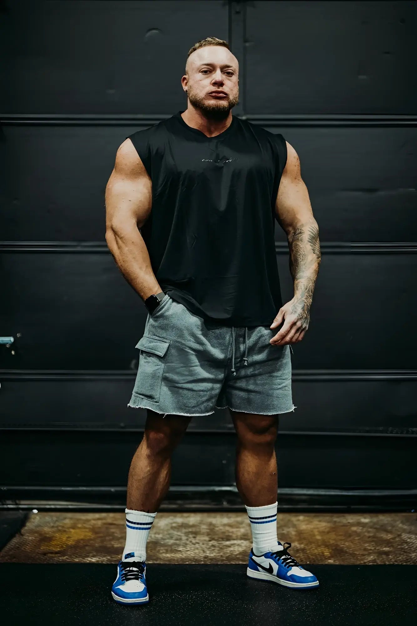 Black sleeveless athletic muscle tee with subtle chest logo designed for active wear and performance