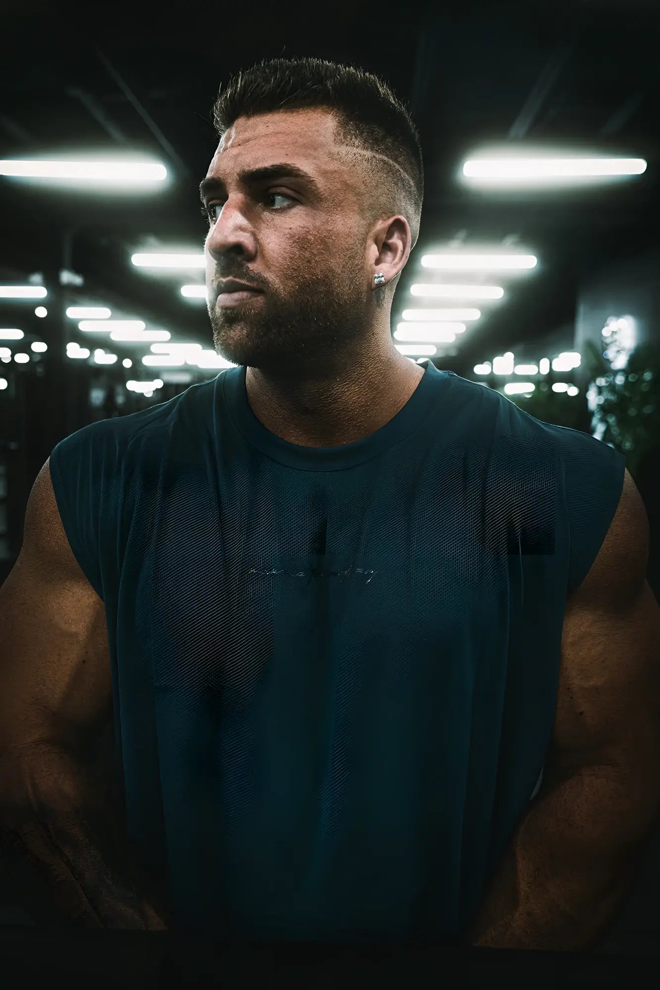 Dark teal sleeveless athletic tank top with subtle embroidered branding across the chest from jn active muscle tee navy blue