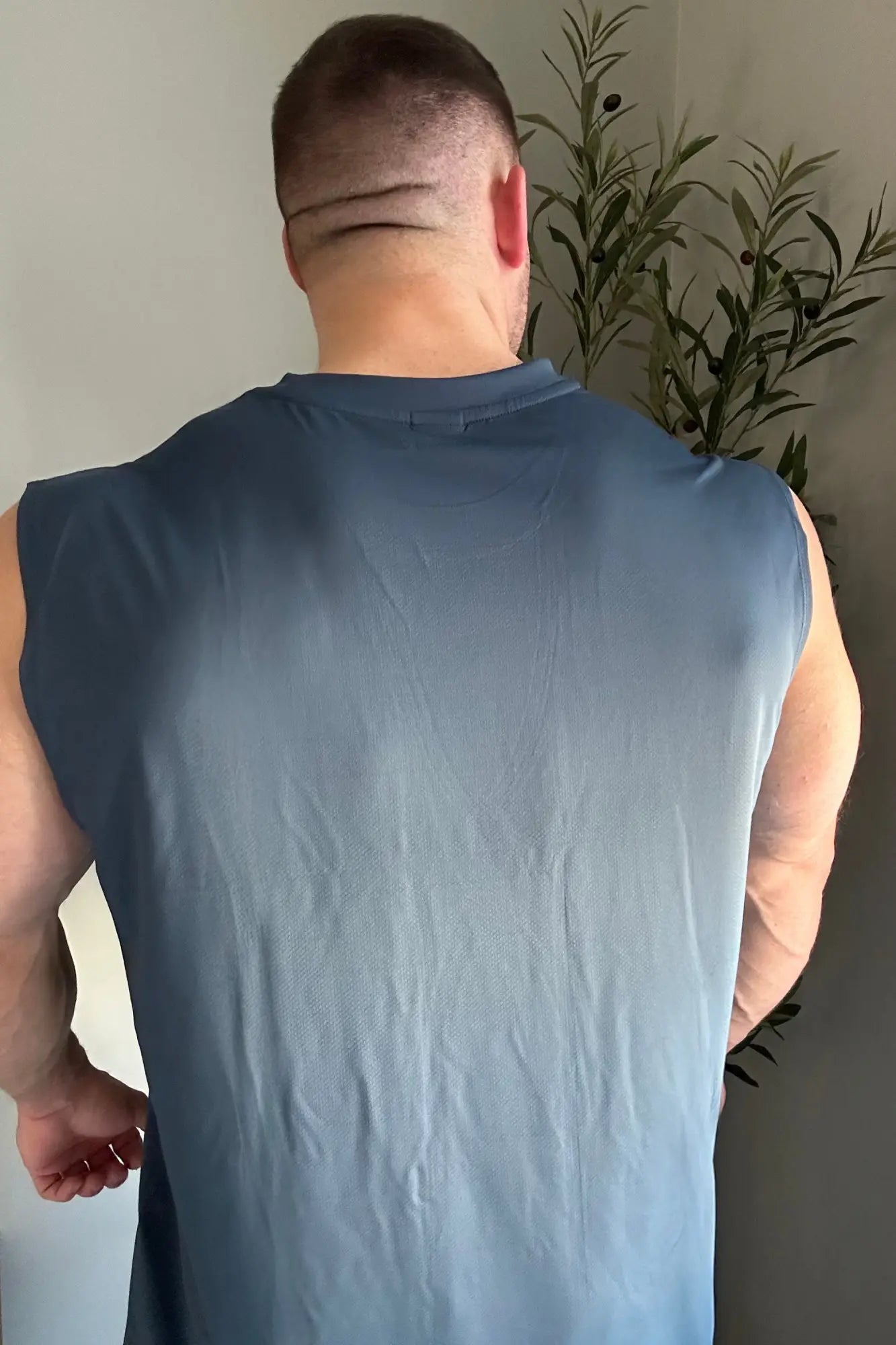 A man wearing a sleeveless light blue JN Active muscle tee designed for athletic performance and comfort