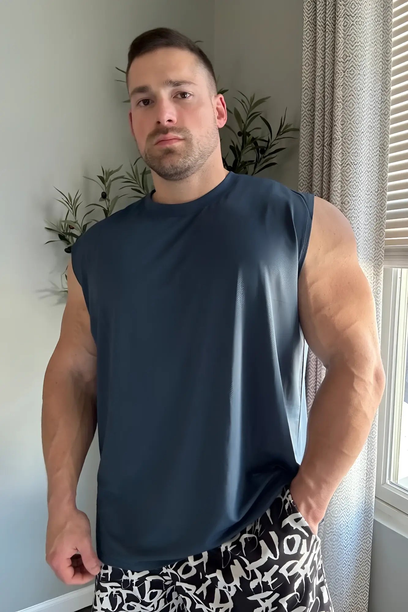 Navy blue sleeveless muscle tee made from breathable fabric for active wear and workout performance