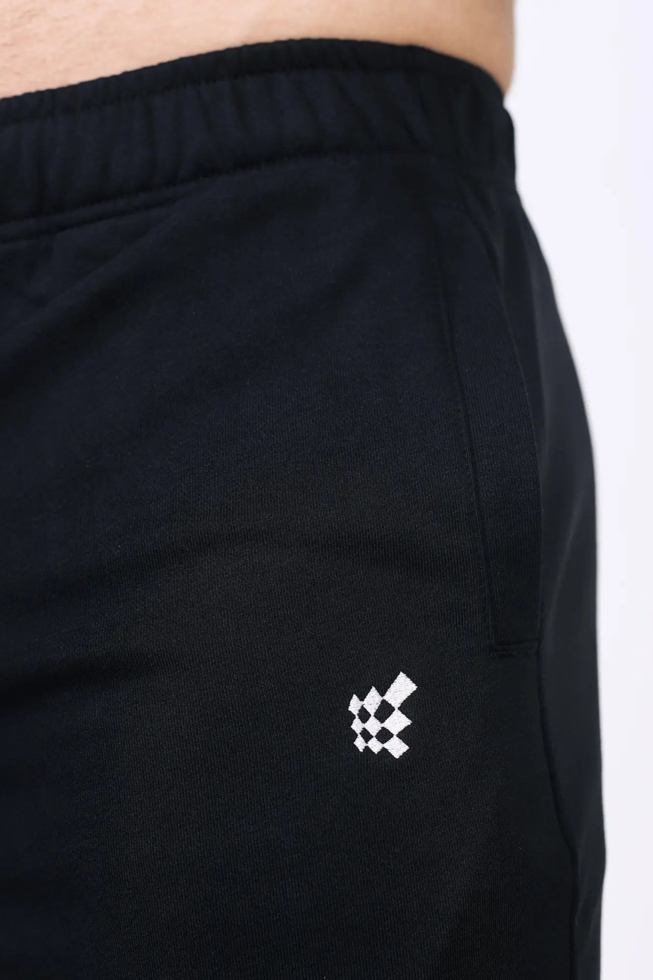 Jed North Lax straight cut joggers in black feature a subtle white geometric logo embroidered on the lower leg