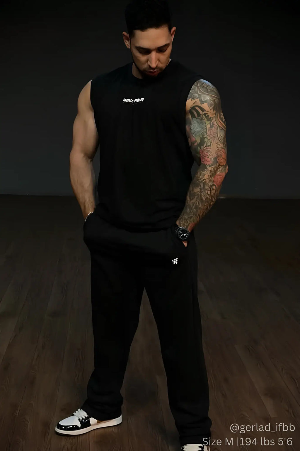 Black sleeveless athletic top with small white logo on chest paired with jed north lax straight cut joggers in black
