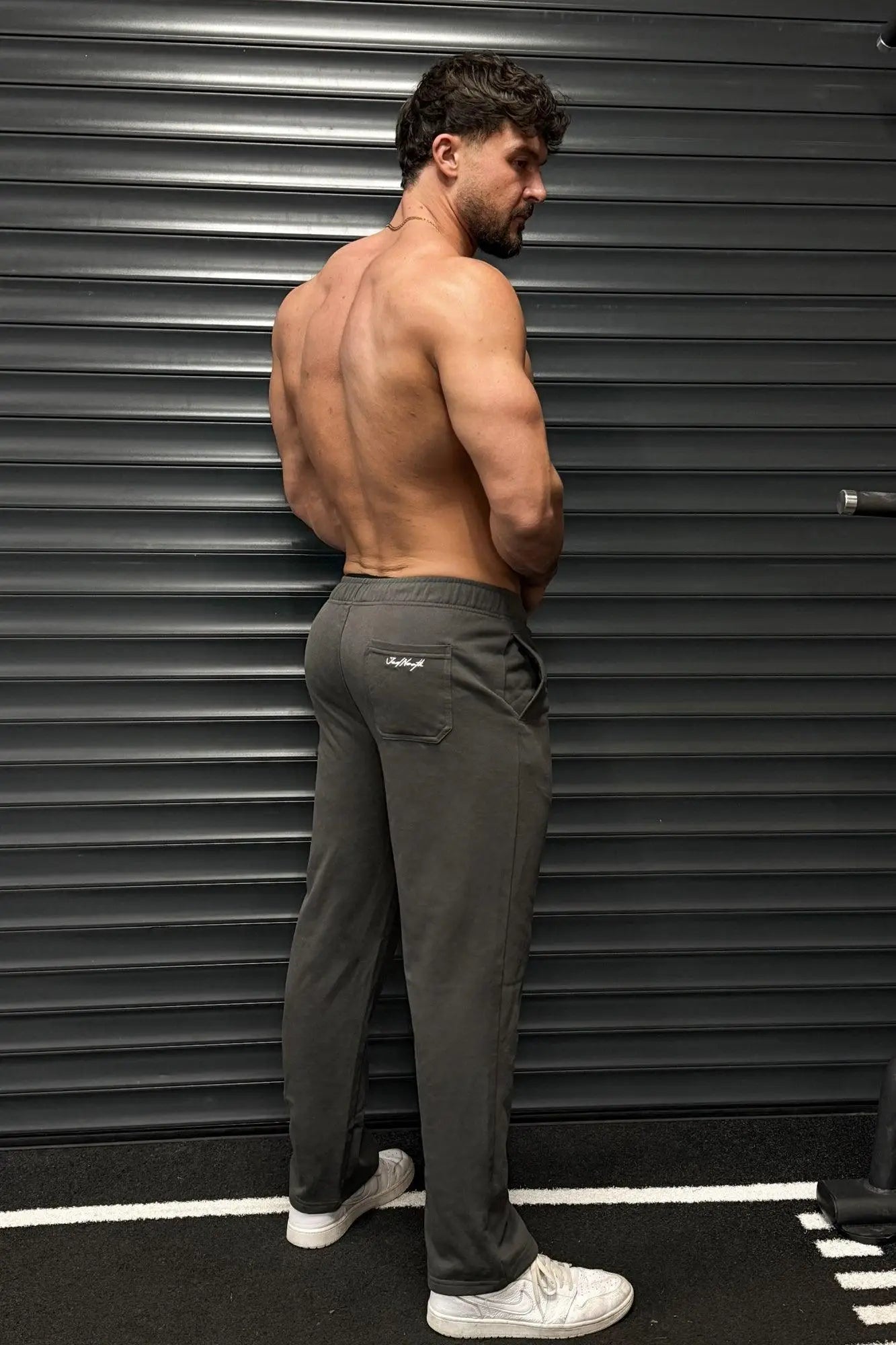 Back side of dark gray Jed North lax straight cut joggers with subtle brand logo on the back pocket