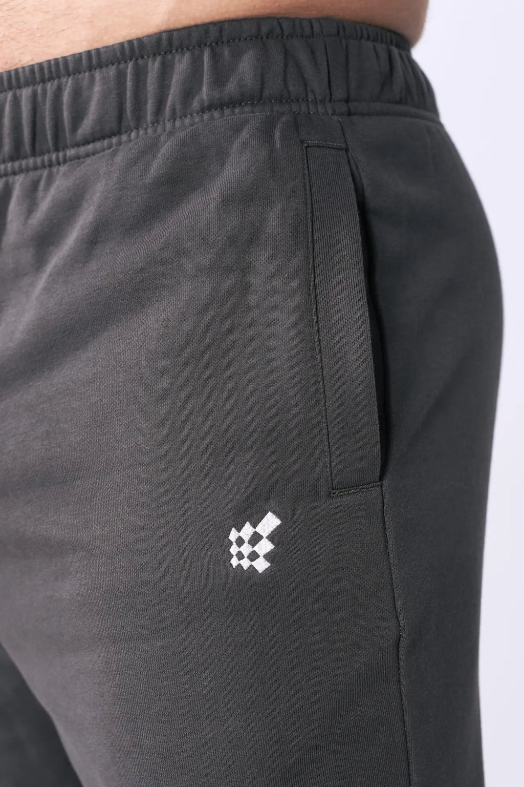 Dark gray Jed North lax straight cut joggers with subtle white checkered logo embroidered on thigh