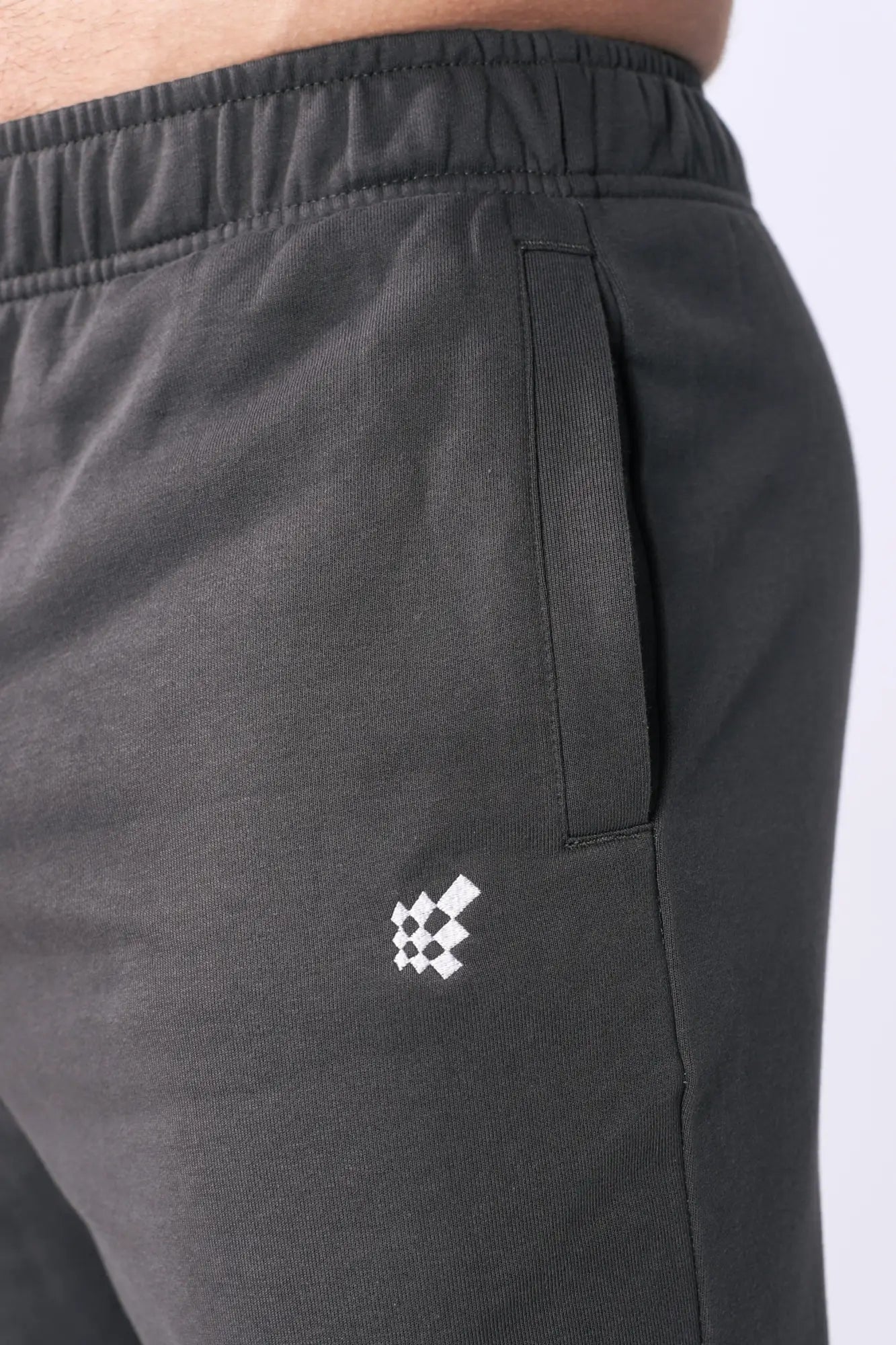 Dark gray Jed North lax straight cut joggers with subtle white checkered logo embroidered on thigh