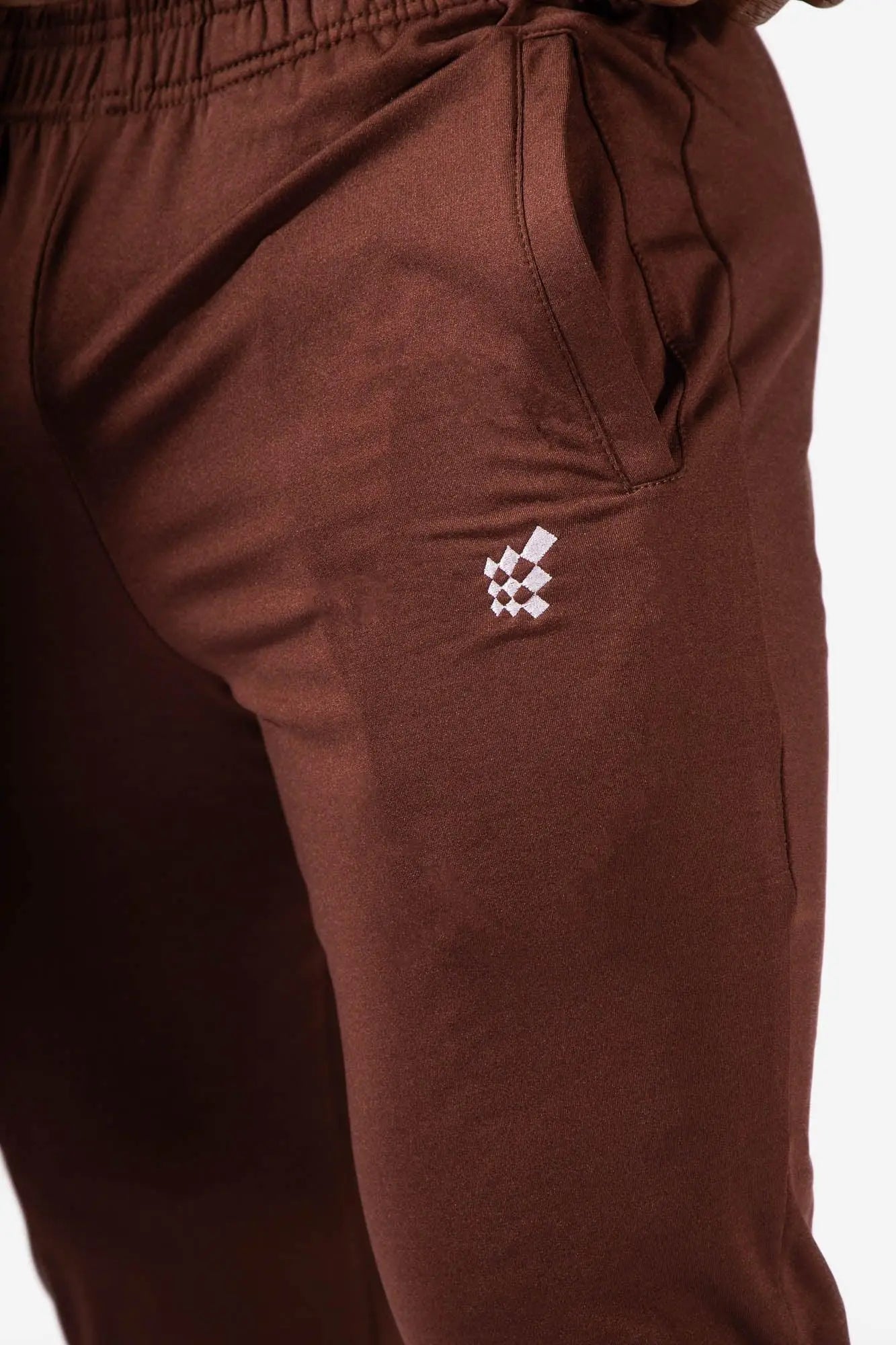 Brown jed north matrix tapered joggers with a small white checkered logo on the thigh in athletic fabric