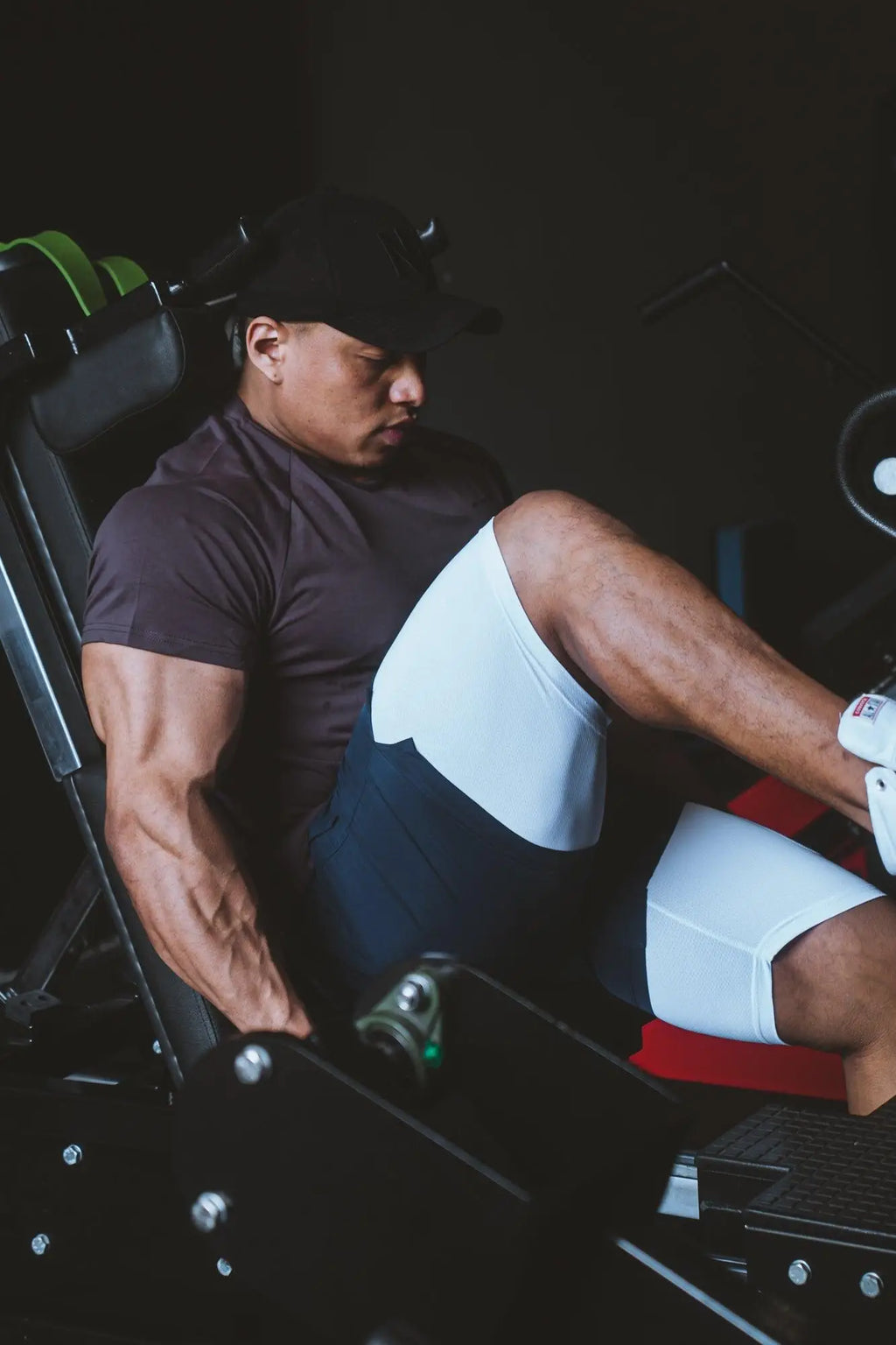 A man using a leg press machine wearing Jed North men’s navy 2-in-1 active 5 inch training shorts 2.0