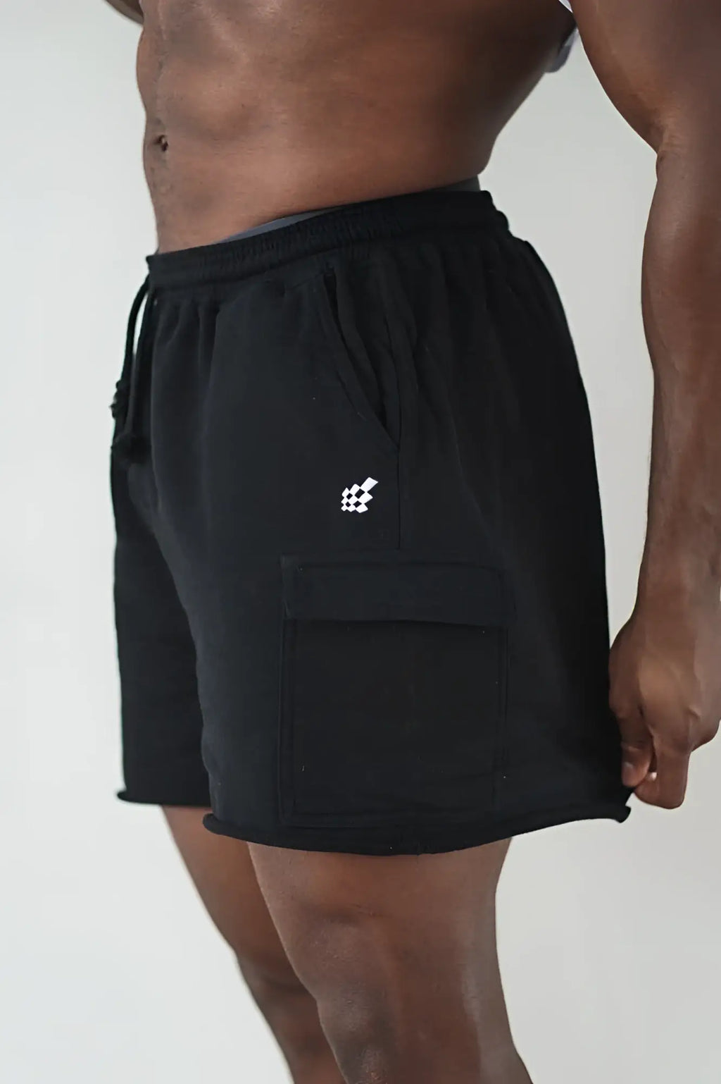 Men’s cargo sweat shorts in black with a drawstring waistband and a small white logo on the thigh