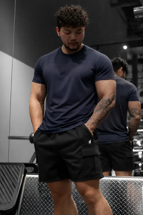 Men’s navy blue short-sleeved athletic t-shirt with a subtle chest logo paired with black cargo sweat shorts
