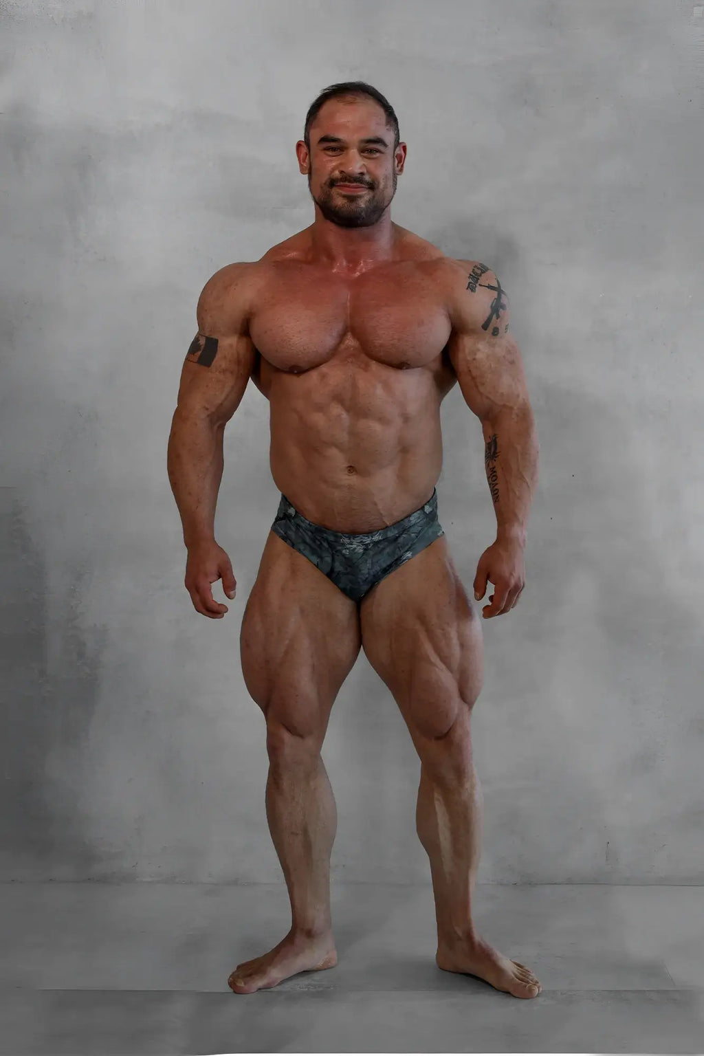 A muscular man wearing men’s classic physique trunks 2 inch seam in camo dark patterned briefs from the back side