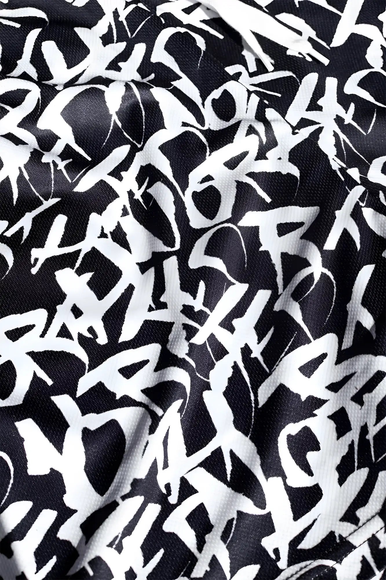 Black fabric Jed North men’s fast-dry training shorts with bold white graffiti-style lettering pattern
