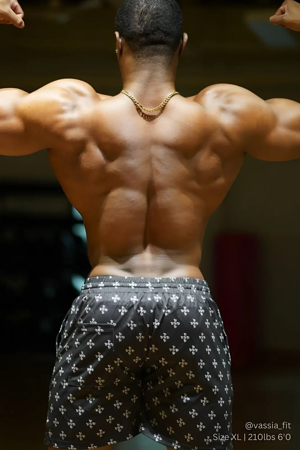 A gold chain necklace worn around the neck paired with jed north men’s fast dry 5 inch training shorts jn cross