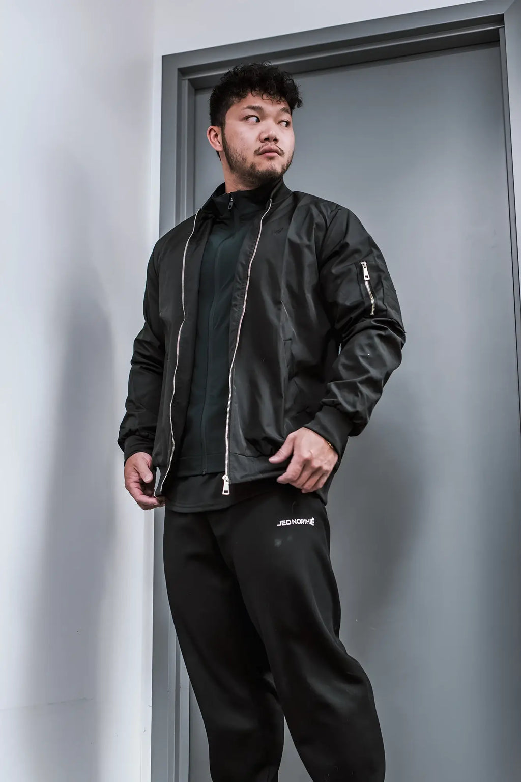 Men’s premium black bomber jacket with silver zippers and subtle stitching details in durable fabric