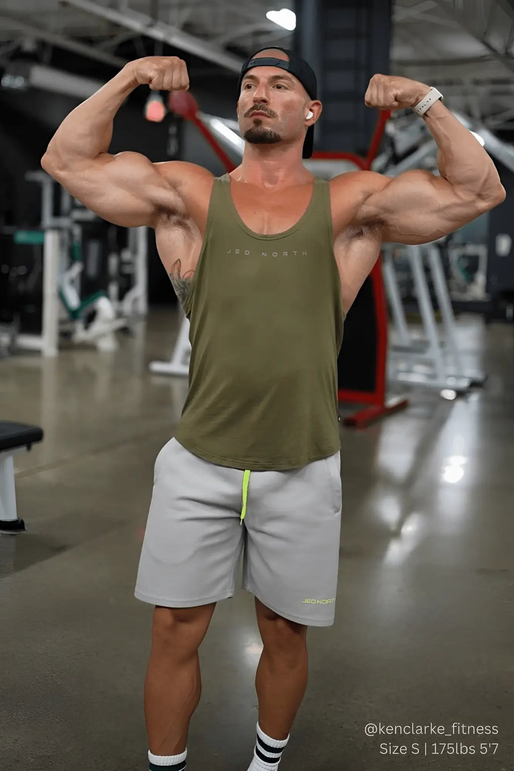 Olive green tank top with subtle logo paired with men’s pro mesh shorts 8 inch light gray for active wear