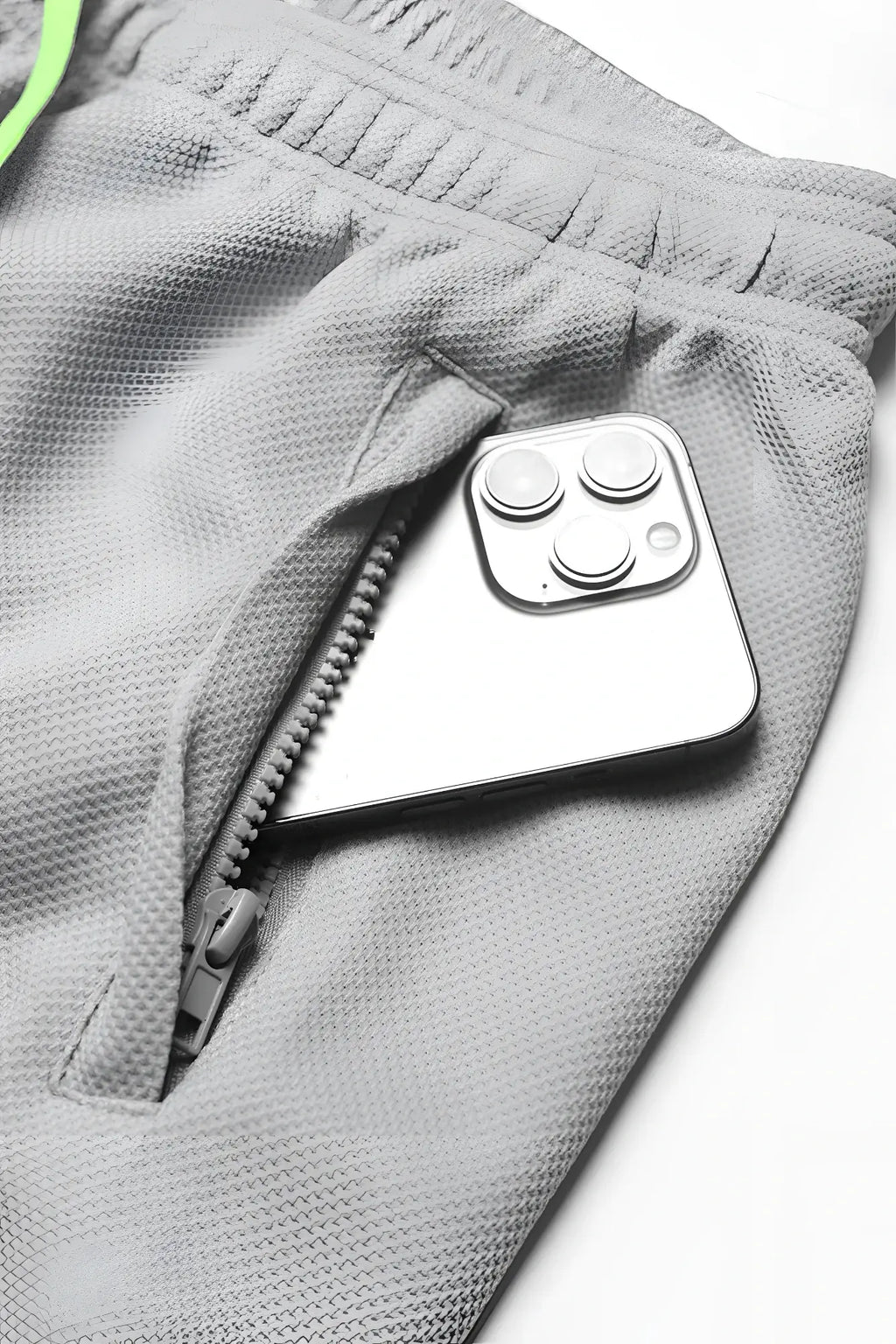 A sleek silver iphone with triple camera rests in the zippered pocket of men’s pro mesh shorts 8 light gray
