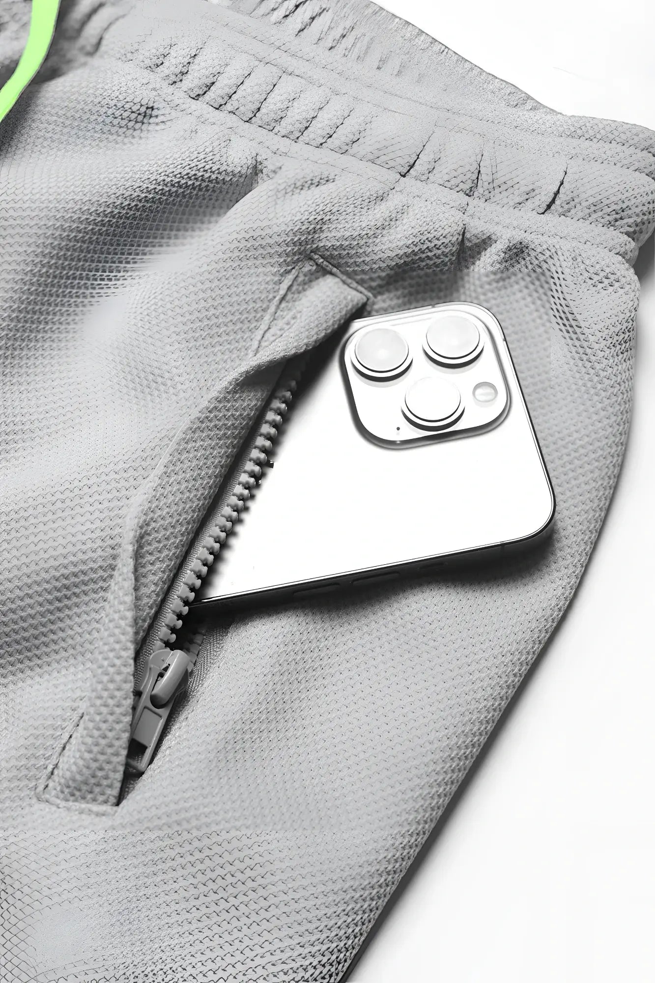 A sleek silver iphone with triple camera rests in the zippered pocket of men’s pro mesh shorts 8 light gray