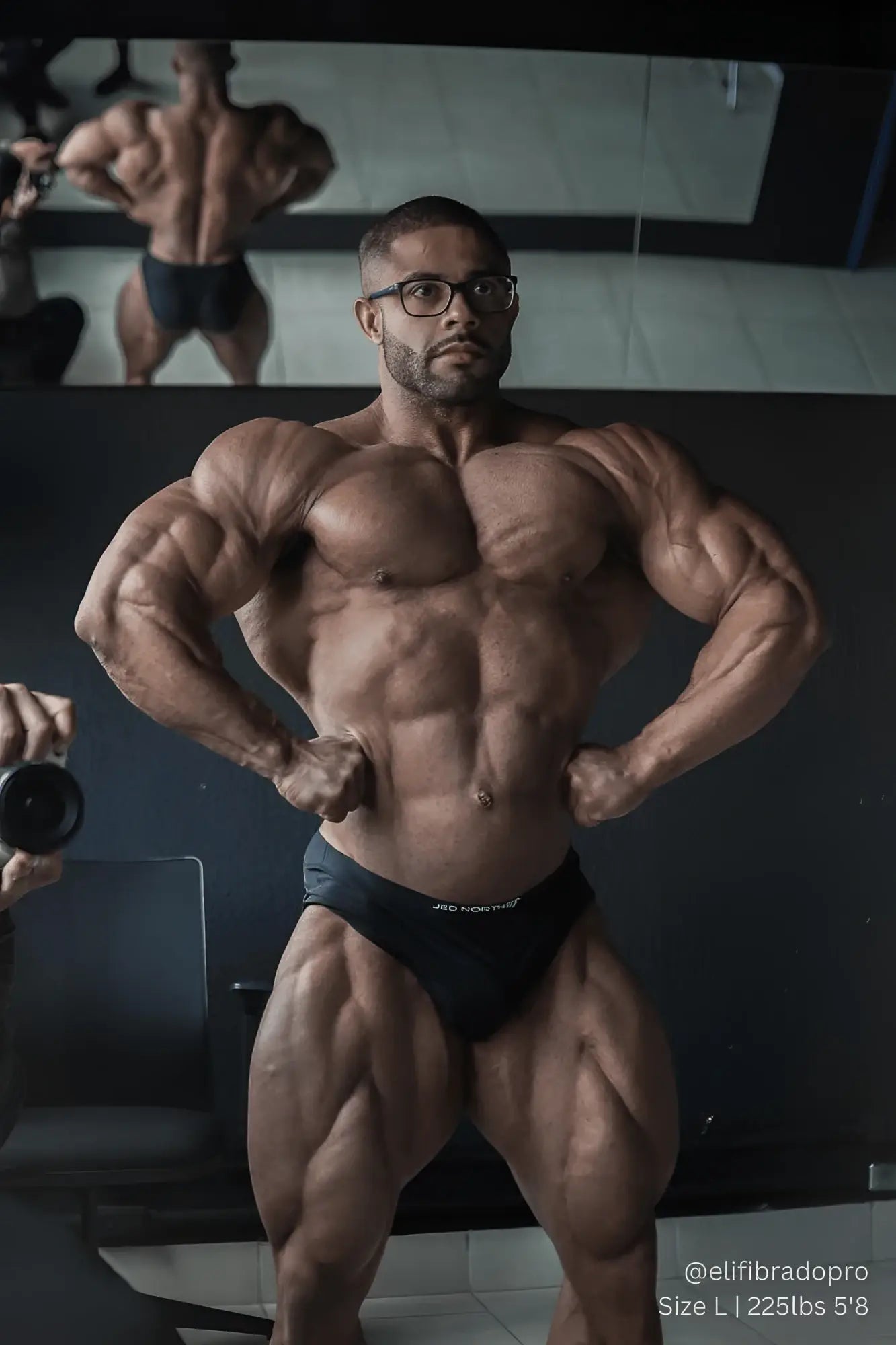 A muscular man wearing black jed north seamless muscle-fit boxers with jed horton logo and glasses and beard