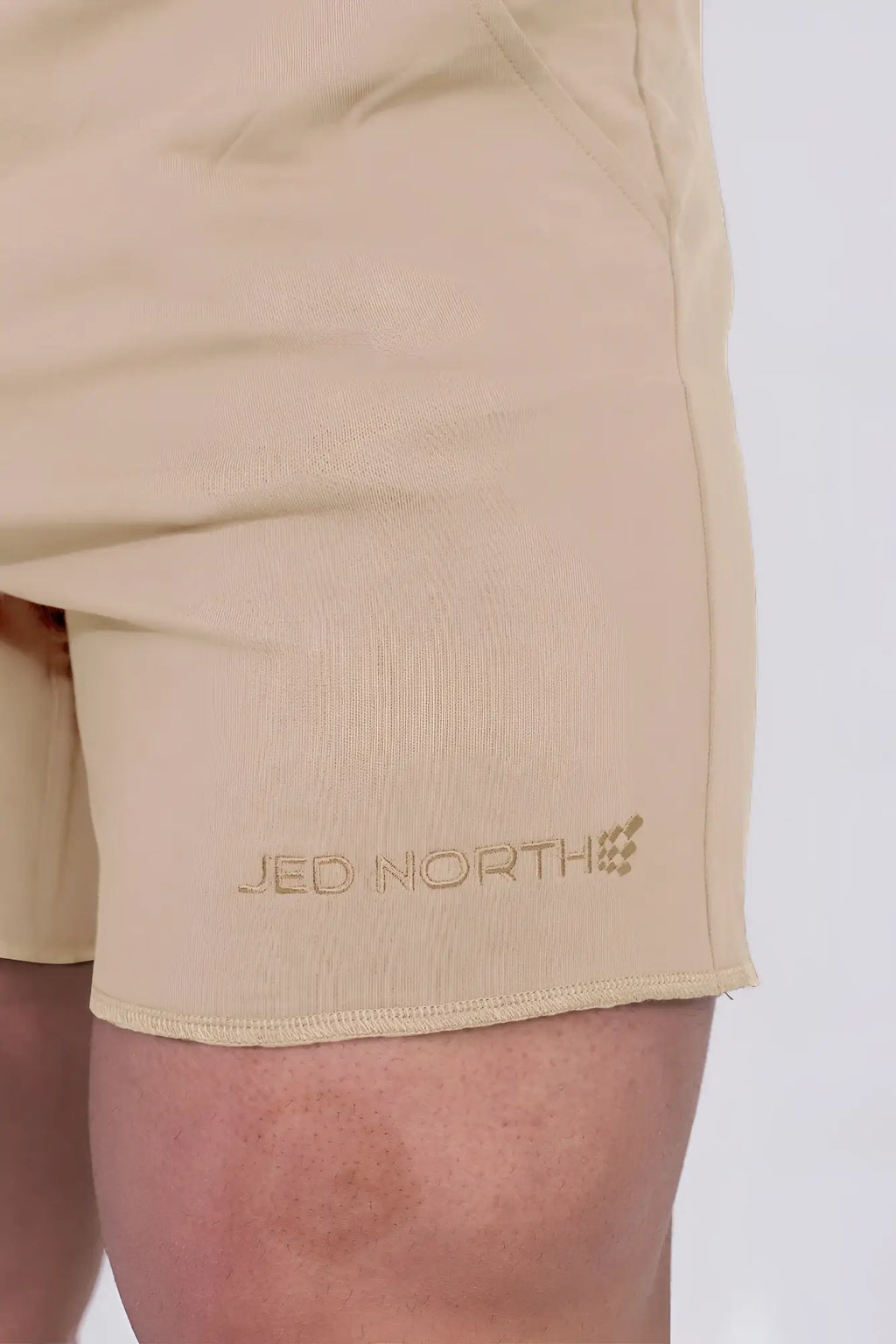 Beige Jed North Motion 5 inch varsity sweat shorts with subtle embroidered logo on lower leg in khaki color