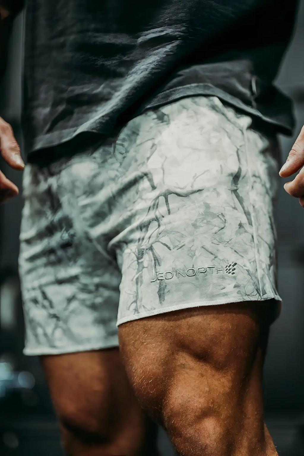 Motion 5 inch varsity sweat shorts in gray and white leaf camo with subtle jed north logo embroidered on the lower left leg